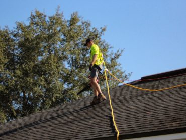 a man on a roof working with a rope