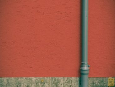 a red wall with a blue street light next to it